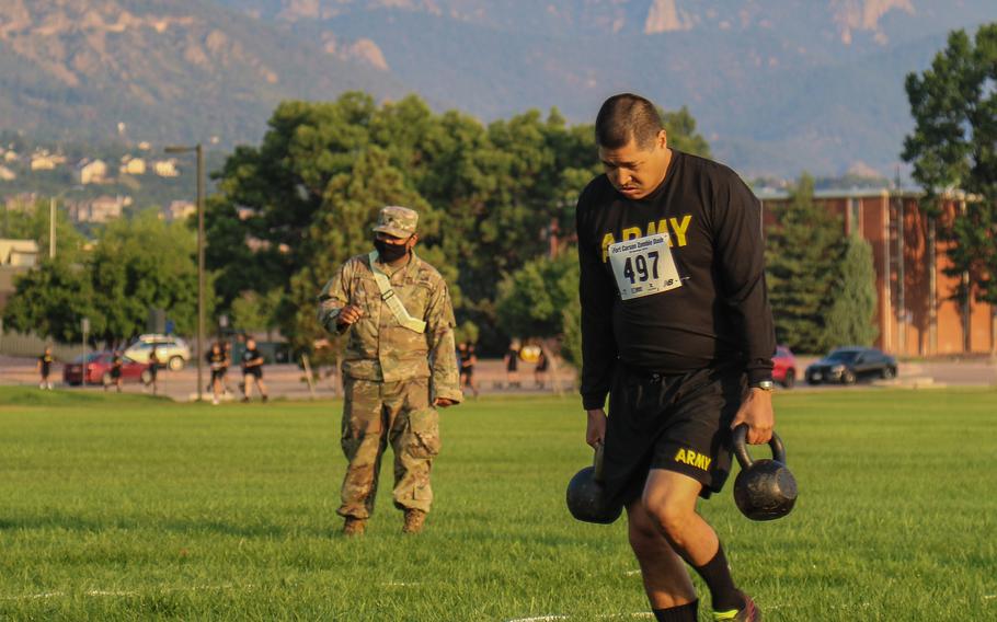 Chief Warrant Officer 3 Justin Montes, of the 4th Infantry Division, carries kettlebells during the sprint-drag-carry event of the Army Combat Fitness Test on July 21, 2021, at Fort Carson, Colo. Sgt. Maj. of the Army Michael Grinston didn't have to change his biographical blurb on Twitter, in line with a pledge he made, when soldiers couldn't register 500,000 ACFT scores by the Army's 246th birthday. 