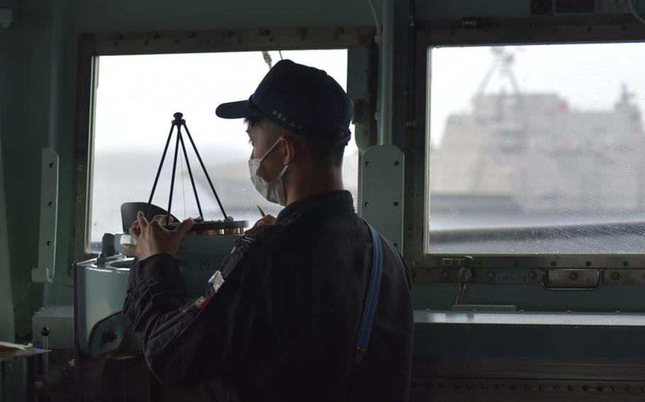 A sailor navigates the Japan Maritime Self-Defense Force destroyer JS Kirisame during an exercise with the U.S. Navy near the Solomon Islands, Monday, Aug. 8, 2022.