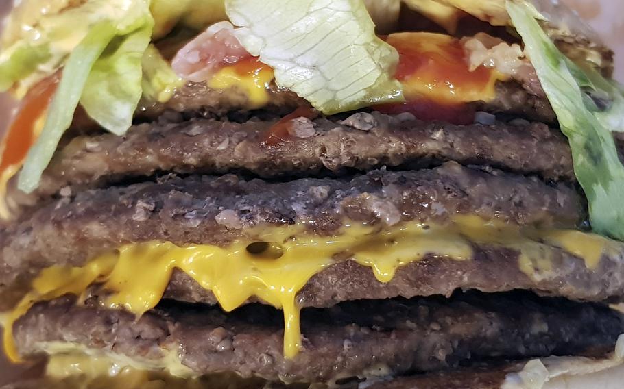 A towering hamburger includes five meat patties.