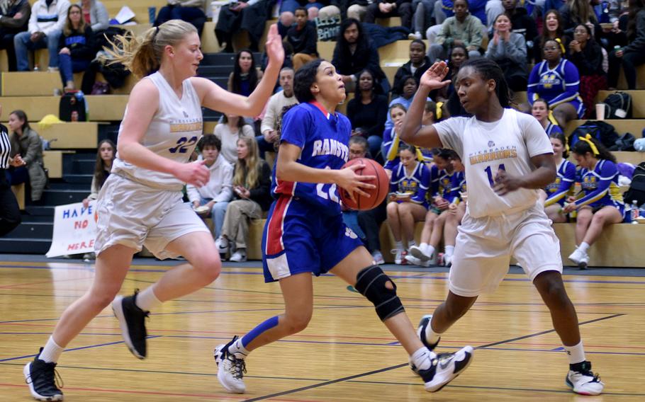 Ramstein's Aliya Jones prepares to go for a layup while Wiesbaden's Gwen Icanberry, left, and Brandi Stanford defend in the first quarter of Tuesday's game at Wiesbaden High School in Wiesbaden, Germany. The Warriors took first palce outright in Division I with a 48-46 victory.