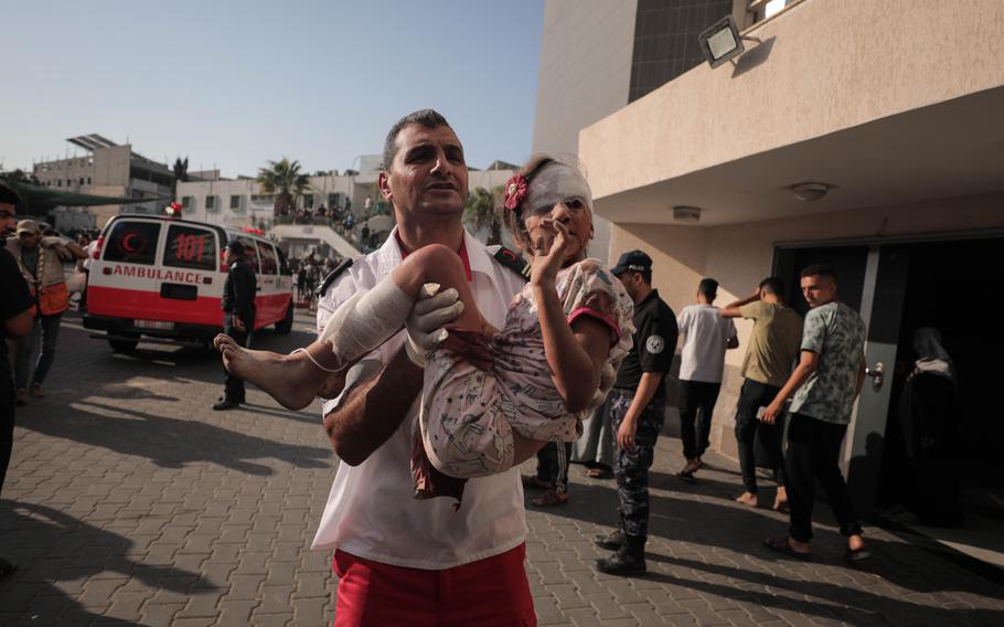 A paramedic carrying a young child with injuries arrives at al-Shifa hospital on Oct. 12, 2023.