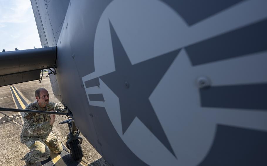 An airman performs preflight checks on an aircraft.