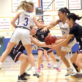 Zama's Lorelei Holt and Isabella Rivera Munoz fight for a loose ball against Yokota's Charlotte Rhyne and Alicia Tanoue during Friday's DODEA-Japan/Kanto Plain girls basketball game. The Trojans won 30-29 in overtime.