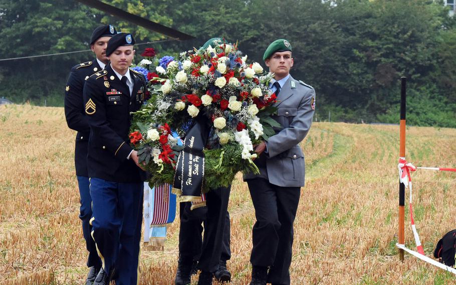 U.S. and German soldiers carry wreaths Aug. 18, 2021, from a CH-47 Chinook helicopter to the memorial site for soldiers killed in a Chinook crash 50 years ago, near Pegnitz, Germany.