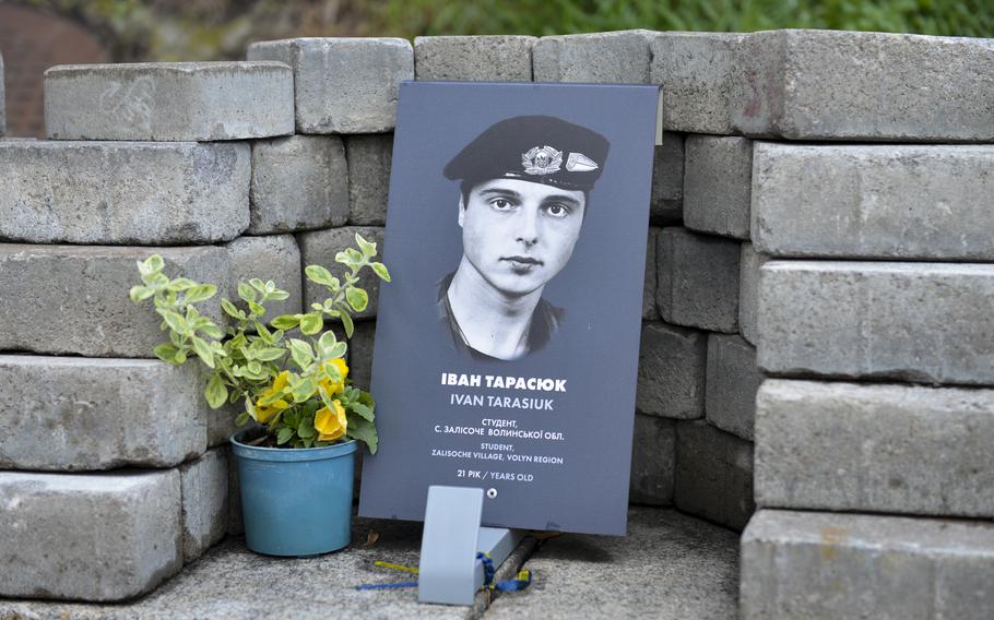A pot of pansy flowers adorns a marker for a Ukrainian soldier killed at the age of 21, in a memorial next to the Maidan Nezalezhnosti, Kyiv’s central square, on Oct. 26, 2022.