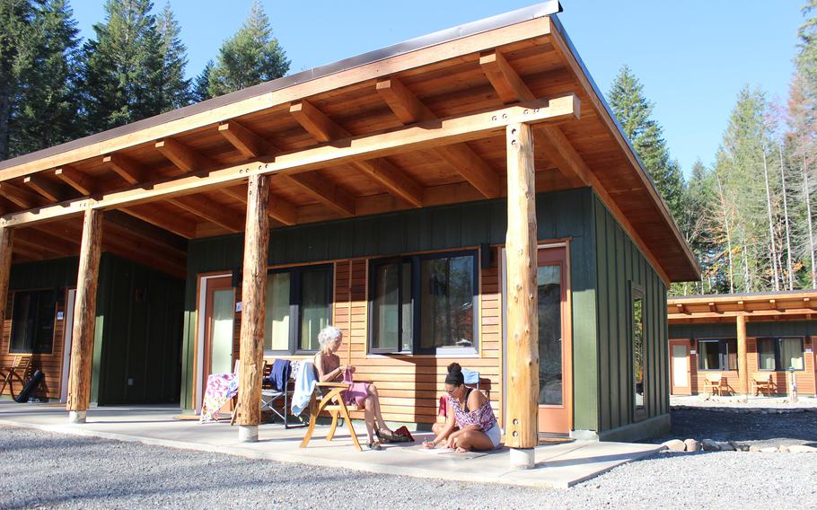 Eugene resident Doris Reynolds crochets and Portland resident Aketi Merrick draws in front of their cabin in the Grove, one of the new lodging options built at Breitenbush Hot Springs in the wake of destructive September 2020 fires. The mother and daughter have been planning this visit for over three years, but had to reschedule due to the pandemic, wildfires and reconstruction. 