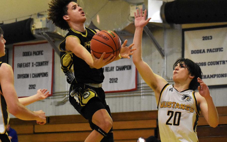 Humphreys' Brandon Howell drives against ASIJ's Kian Takizawa. The Mustangs won the quarterfinal 61-48.