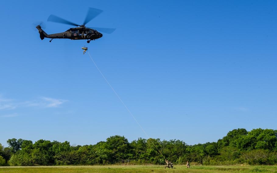 Best Ranger competitors evacuate a simulated casualty onto a hovering Black Hawk helicopter during the annual competition’s second day held in downtown Columbus, Ga., on Saturday, April 15, 2023. 