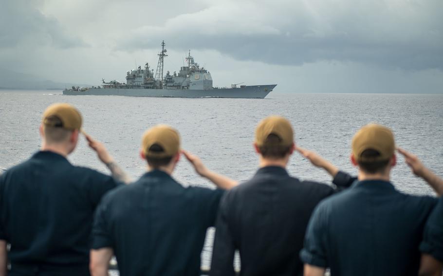 Sailors aboard the USS Shiloh salute the USS Antietam as it steams past, March 9, 2020. The Navy is ending a controversial program that requires sailors to move up the ranks within a certain timeframe or face discharge, personnel officials said.