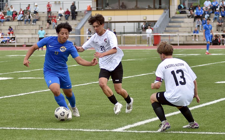 Ramstein midfielder Jovan Paucar holds off Kaiserslautern midfielder Ethan Dezeda while Dezeda's teammate, outside midfielder Nico Engeman, comes to help during a Division I semifinal match at the 2025 DODEA European championships on May 21, 2025, at Kaiserslautern High School in Kaiserslautern, Germany.