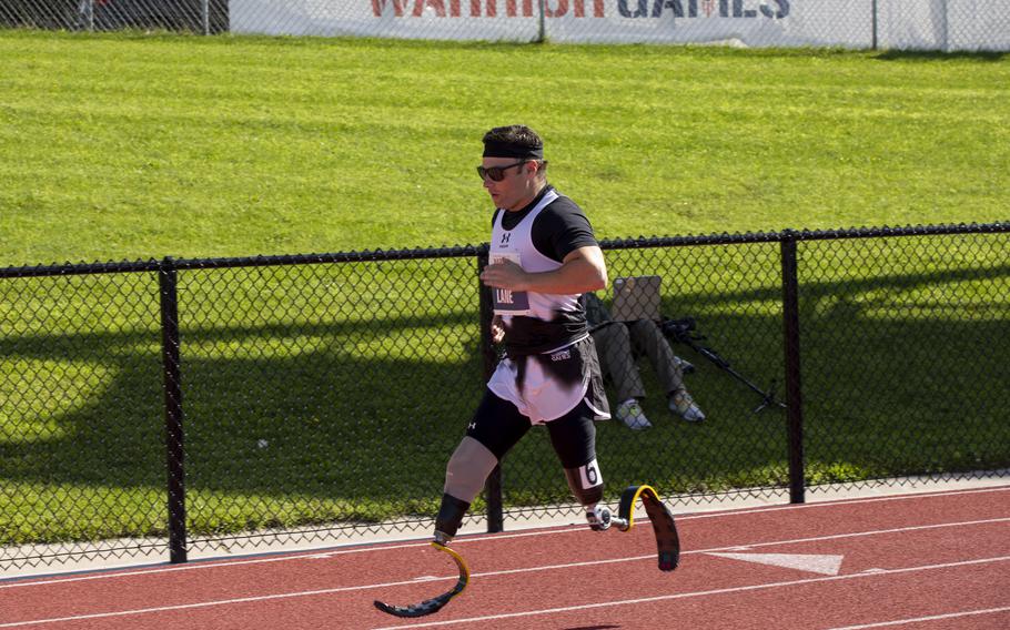 A man with prosthetic legs runs down a track.