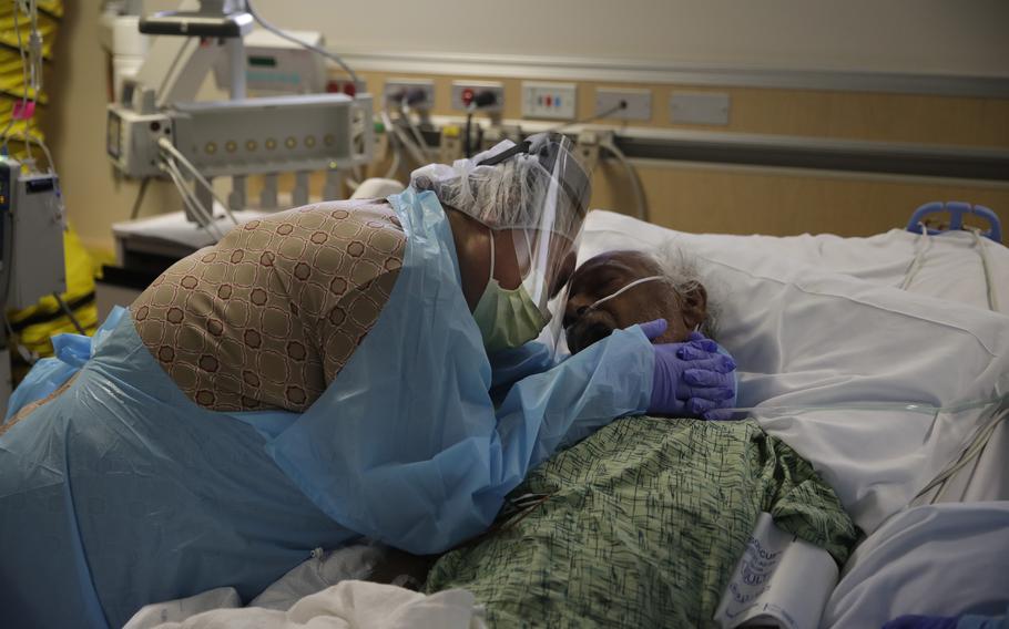 In this July 31, 2020, photo, Romelia Navarro, 64, weeps while hugging her husband, Antonio, in his final moments in a COVID-19 unit at St. Jude Medical Center in Fullerton, Calif. On Monday, Oct. 11, 2021, California's coronavirus death toll reached 70,000. 