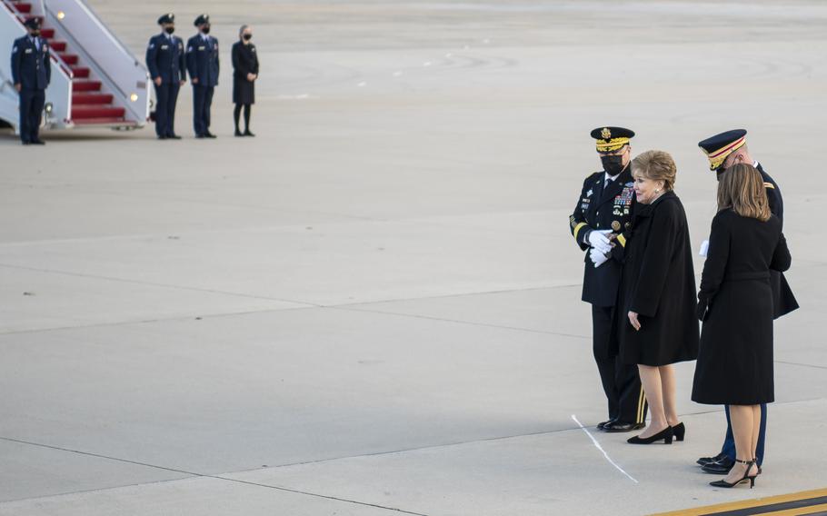 Chairman of the Joint Chiefs of Staff Gen. Mark Milley, left, escorts Elizabeth Dole as she watches an honor guard carry the casket of her late husband, WWII veteran and former Kansas Sen. Bob Dole on the tarmac at Joint Base Andrews, Md., on Friday, Dec. 10, 2021. At right, Army Maj. Garrett Beer escorts the Doles' daughter Robin.