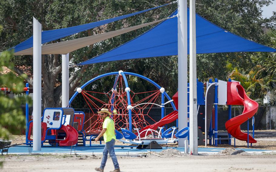 A worker walks past a completed playground at Vila Brothers Park on May 22, 2023, in Tampa, Fla.