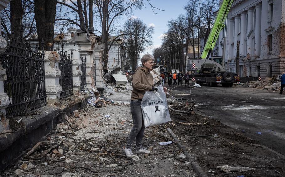 A woman holds a bag at the site of a Russian double missile strike that hit a community center in Ukraine’s central Sumy a day earlier on Sunday.