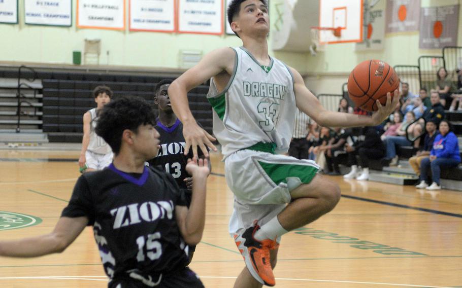 Kubasaki's Ryan Hater puts up a shot against Zion's Aaron Blanc during Tuesday's Okinawa boys basketball game. The Dragons won 86-42.