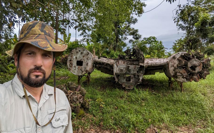 Justin Taylan, founder and director of Pacific Wrecks, stands beside World War II aircraft wreckage in Papua New Guinea in May 2023.