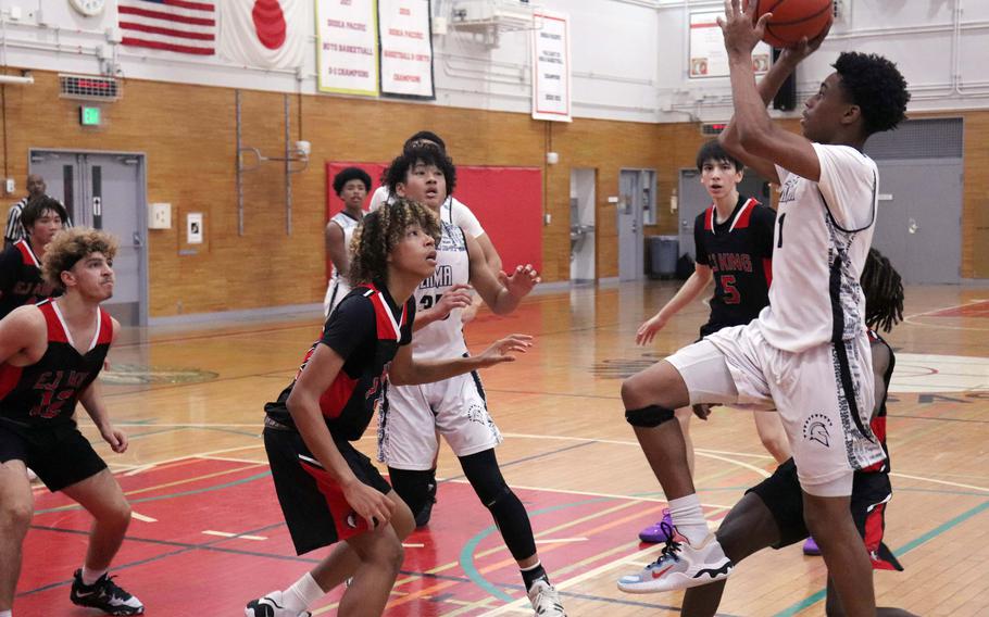 Zama's Ayden Helton shoots against E.J. King during Saturday's DODEA-Japan boys basketball game. The Trojans won 71-59.