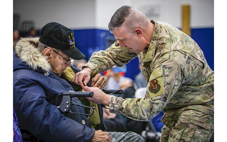 Maj. Gen. Torrence Saxe, adjutant general of the Alaska National Guard and commissioner of the Department of Military and Veterans Affairs, pins the Alaska Heroism Medal on Cpl. Bruce Boolowon on March 28, 2023, in Gambell, Alaska. Boolowon is the only surviving member of a 16-person search-and-rescue party that responded to the shootdown, crash and explosion of a U.S. Navy plane on June 22, 1955. 