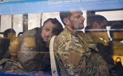 FILE - Ukrainian servicemen sit in a bus after they were evacuated from the besieged Mariupol's Azovstal steel plant, near a remand prison in Olyonivka, in territory under the government of the Donetsk People's Republic, eastern Ukraine, Tuesday, May 17, 2022. Breaking its silence on prisoners of war, the Red Cross said Thursday, May 19, 2022 it has registered “hundreds” of Ukrainian prisoners of war who left the giant Azovstal steel plant in Mariupol after holding out in a weeks-long standoff with besieging Russian forces. (AP Photo/Alexei Alexandrov, File)