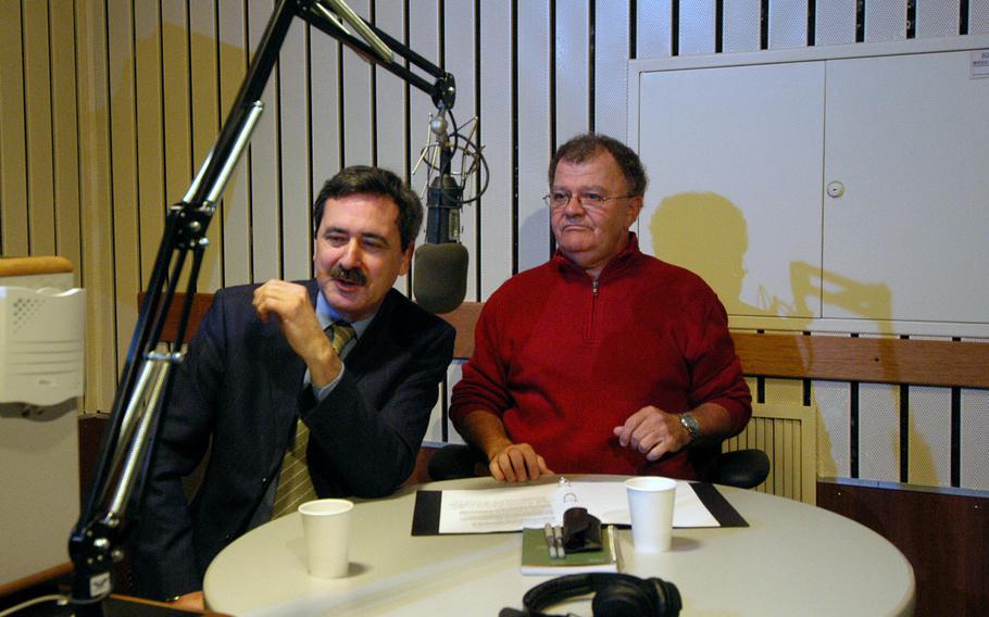 On the last day of broadcasting, Oct. 28, 2004, at the American Forces Network studio in Frankfurt, Germany, Gary Bautell, left, and Herb Glover talk about the station’s history. Bautell died Nov. 23, 2022, at age 80.