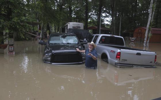 A man waves at Texas Parks & Wildlife Department game wardens as they arrive by boat to rescue residents from floodwaters in Liberty County, Texas, on Saturday, May 4, 2024. (AP Photo/Lekan Oyekanmi)