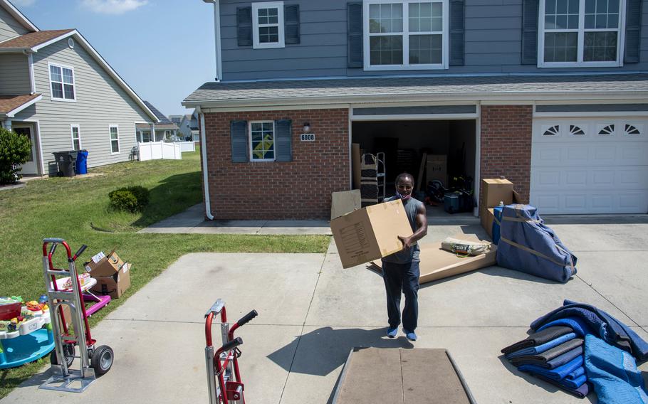 A mover carries a box of household goods onto a truck at Dover Air Force Base, Del., on July 16, 2021. 