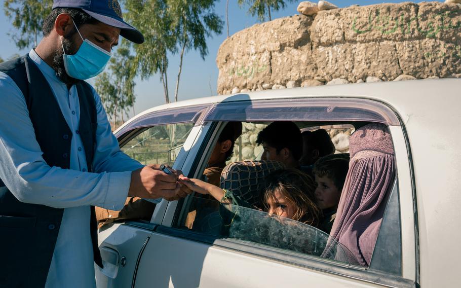 A polio vaccinator immunizes a girl at a checkpoint in Achin, Afghanistan’s northeastern poliovirus epicenter, on Nov. 12, 2023. 