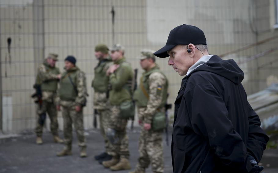 U.S. Marine veteran Mike Postupak watches as Ukrainian soldiers and civilians practice first aid at a training site outside Kyiv on Oct. 27, 2022. Postupak said he quit his private security job and put his life on hold to volunteer in Ukraine.