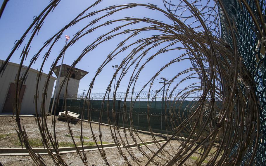 In this Wednesday, April 17, 2019 file photo reviewed by U.S. military officials, the control tower is seen through the razor wire inside the Camp VI detention facility in Guantanamo Bay Naval Base, Cuba. The annual Pentagon policy bill President Joe Biden signed into law this week bars him from taking steps toward closing the controversial detention facility.