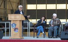 Retired Brig. Gen. Robert Cardenas speaks at the opening ceremony of the 70th Anniversary of Supersonic Flight on October 13, 2017. Behind him is retired Brig. Gen. Chuck Yeager and wife Victoria. Cardenas piloted the B-29 launch aircraft that released the X-1 experimental rocket plane in which Yeager, a captain at the time, became the first man to fly faster than the speed of sound.