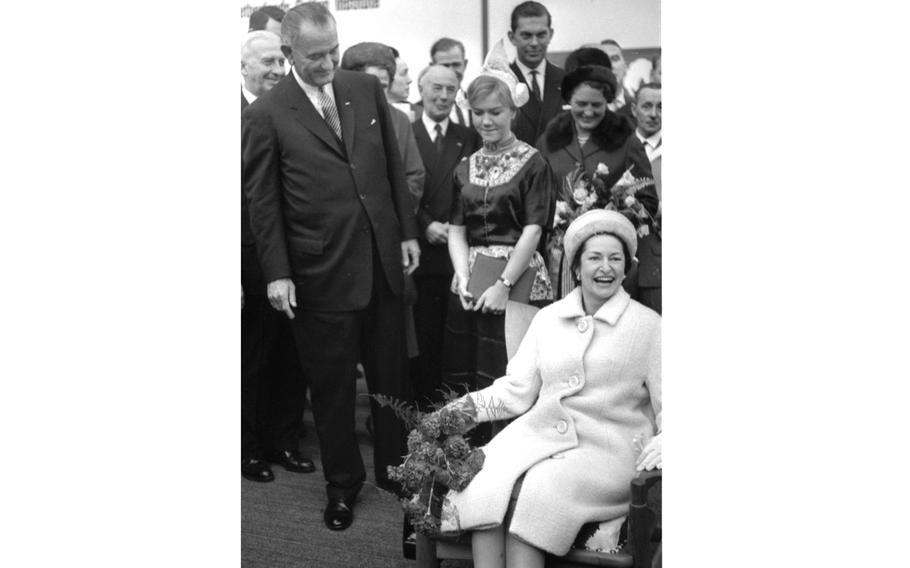 Lady Bird Johnson sits on a chair
