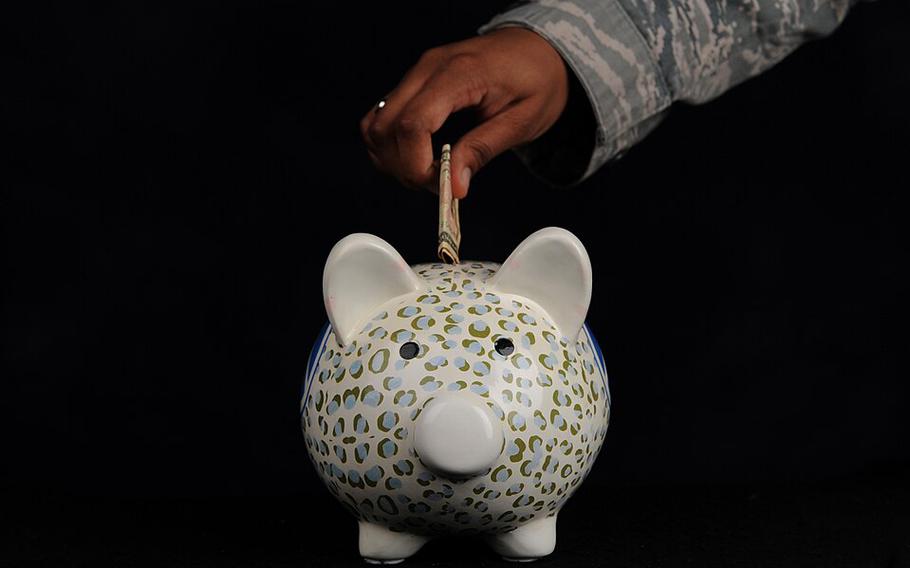 A piggy bank with a hand lowering money into it.