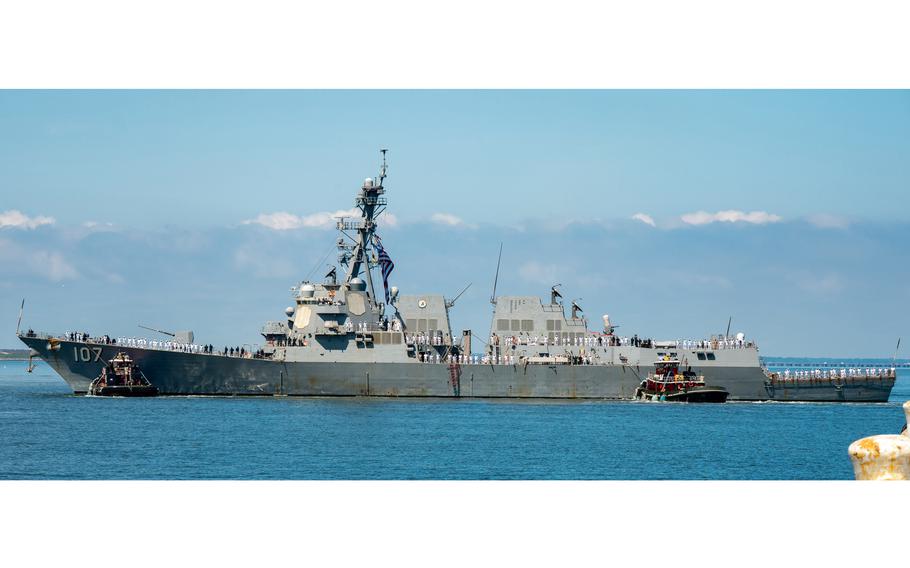 A Navy ship sails into port.