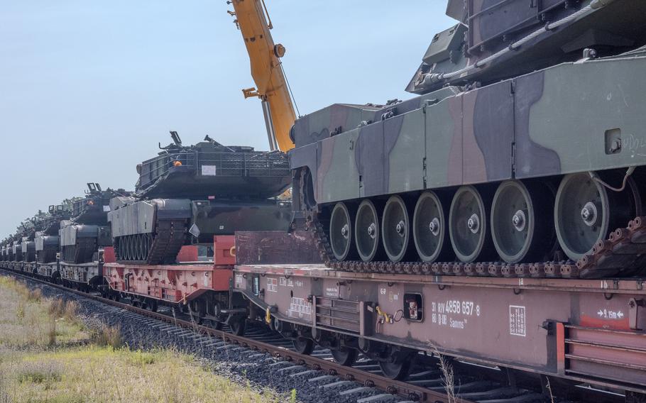 M1 Abrams tanks wait to be moved off a rail car to the staging area at the Powidz APS-2 Worksite in Powidz, Poland,.