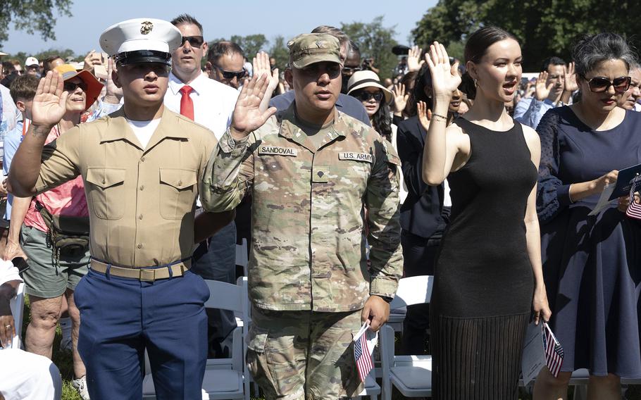 US service members from the Army and the Marine Corps taking the Oath of Allegiance during a naturalization ceremony.