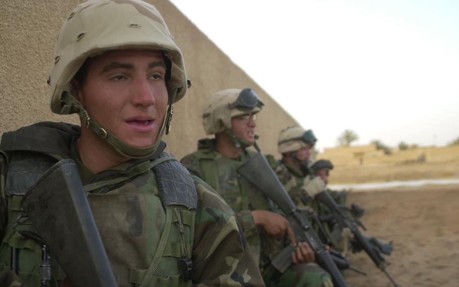 Company G Marines take cover behind a wall surrounding a schoolhouse in Al Fahr, Iraq, during a raid on a local Baath Party headquarters. The raid netted a cahce of weapons, intelligence documents and several Baath Party members.  