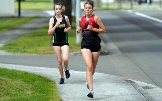 Nile C. Kinnick's Rhianna Kruse and Robert D. Edgren's Hailey Erler negotiate a sidewalk portion of Saturday's DODEA-Japan cross-country meete. Erler finished fifth and Kruse took eighth. Erler is the younger sister of former two-time Far East virtual Division II champion Morgan Erler.
