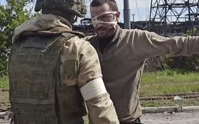 In this photo taken from a video released by the Russian Defense Ministry Press Service on Wednesday, May 18, 2022, a Russian serviceman frisks a Ukrainian soldier after he left the besieged Azovstal steel plant in Mariupol, Ukraine. 