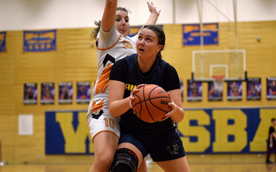 Ansbach sophomore Kennedy Lange looks at the hoop while Spangdahlem senior Talyssa Link defends during a Division III semifinal at the DODEA European Basketball Championships on Feb. 16, 2024, at Wiesbaden High School in Wiesbaden, Germany.