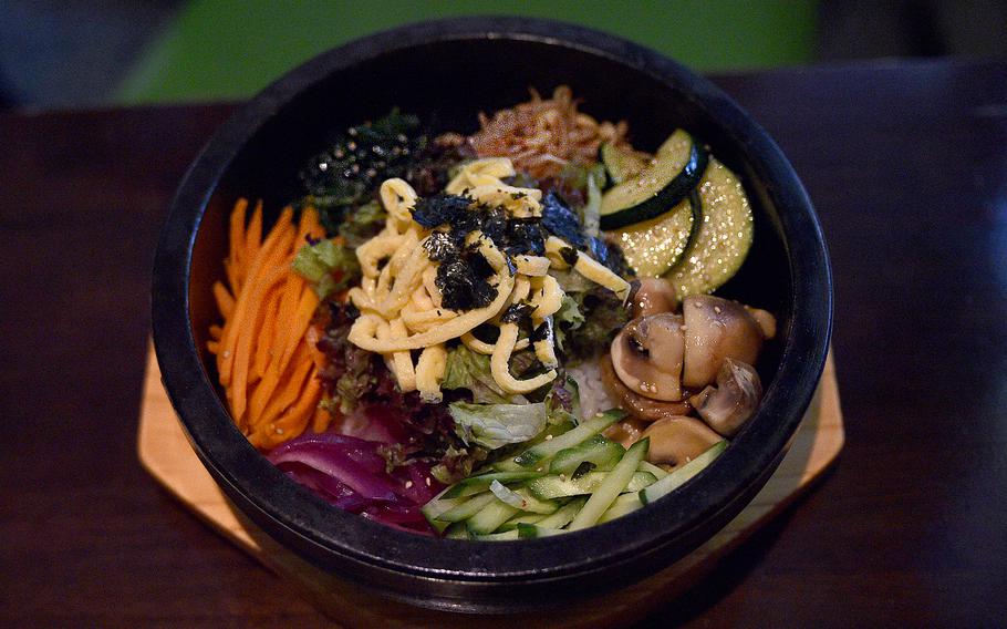 The bibimbap at Restaurant Gautor Korea in Mainz, Germany, consists of a medley of vegetables including mushrooms, zucchini, cucumber and carrots, as seen here during a June 2, 2023, visit. The dish is served with rice and two sauces on the side.