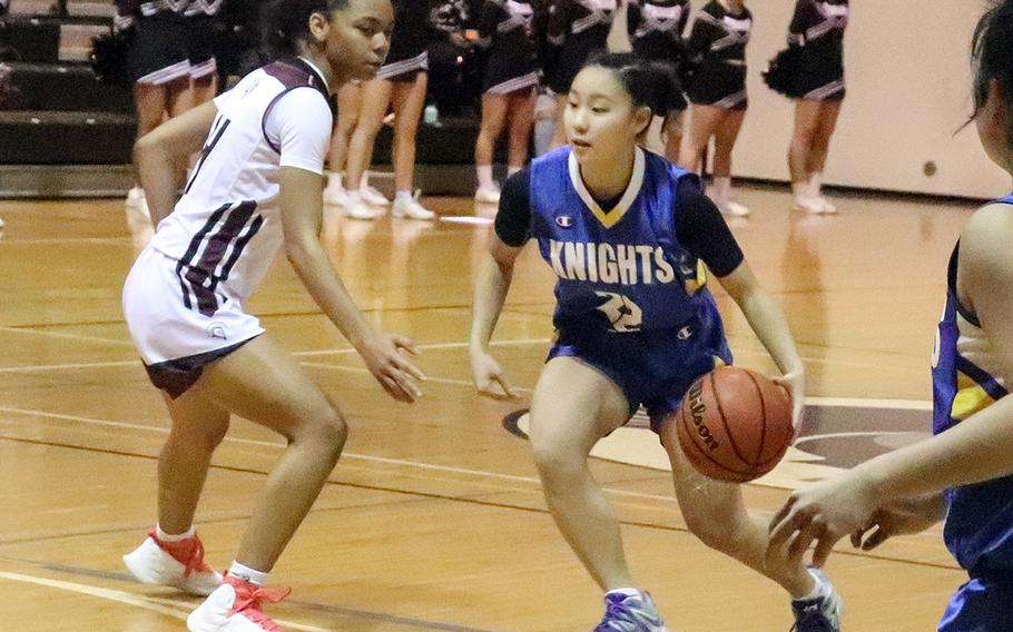 Christian Academy Japan's Sora Inoue dribbles against Zama's Naviah Blizzard during Monday's Kanto Plain girls basketball game. The Trojans won 34-24.