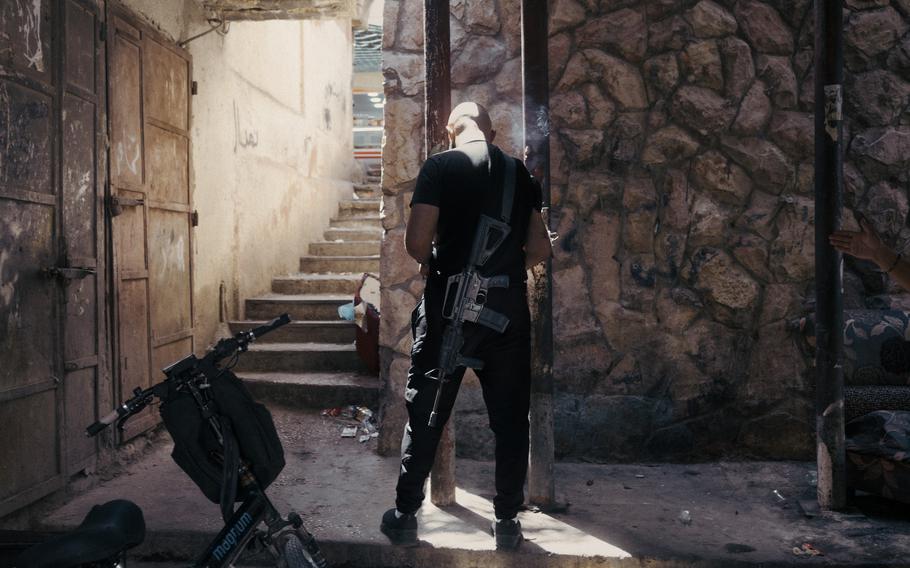 A Palestinian fighter named Ammar stands with his weapon in an area of Balata camp in Nablus, where he is recovering from gunshot wounds he sustained during an attack he carried out near the Alon Moreh settlement. Two gunmen who carried out the attack with him were killed.