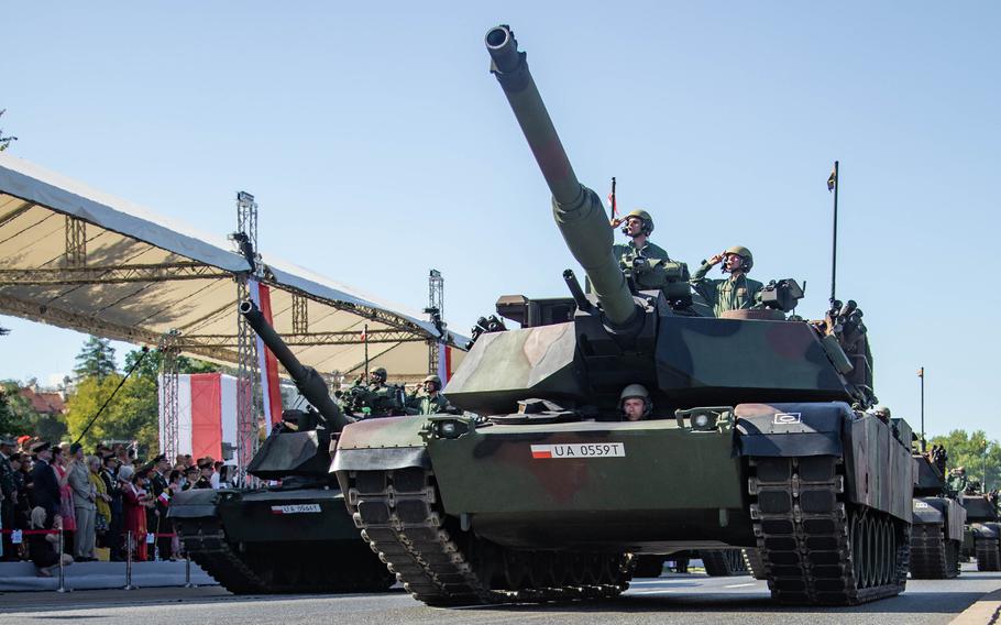 Polish soldiers in M1 Abrams tanks salute officials during a parade in Warsaw, Poland, on Aug. 15, 2023.