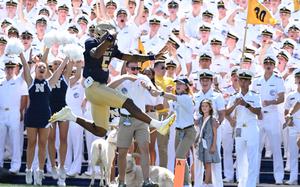 Woodson leaps into the end zone in front of the cheering crowd.