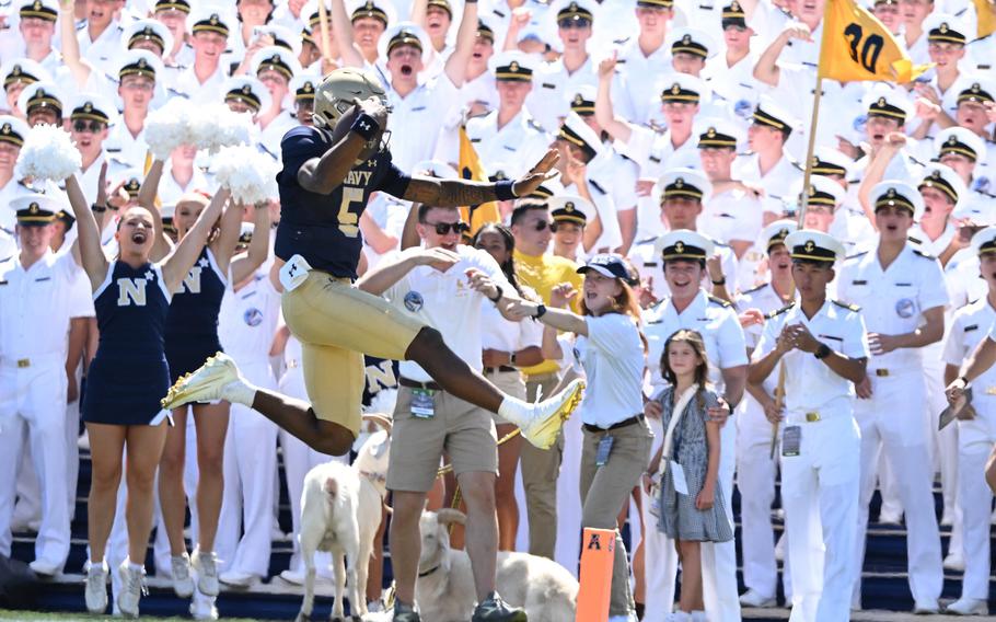 Woodson leaps into the end zone in front of the cheering crowd.