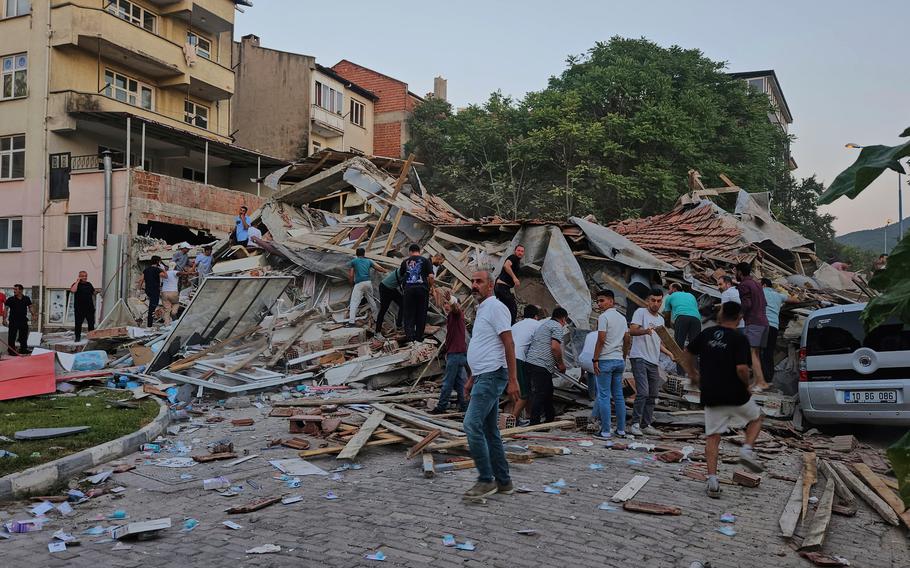 People remove the wreckage of a collapsed building.
