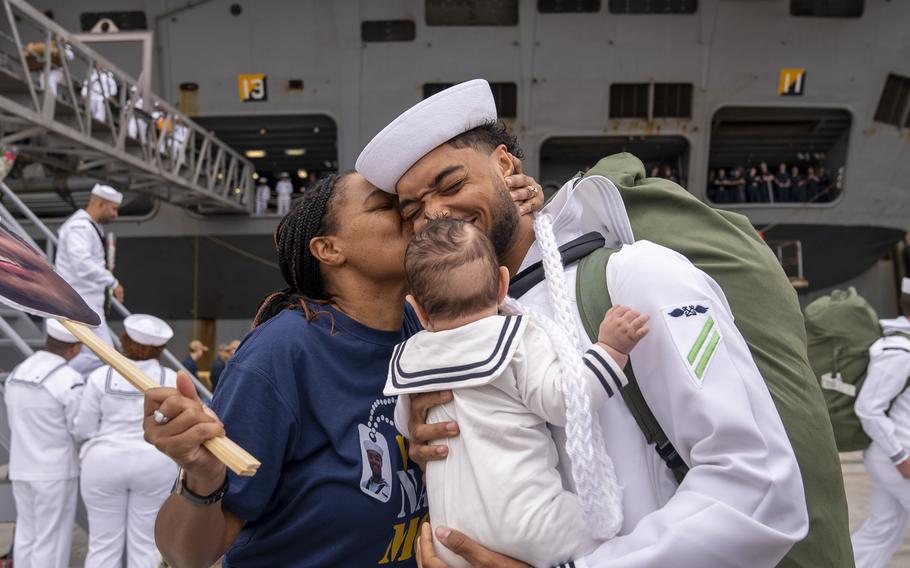 A sailor embraces his family.