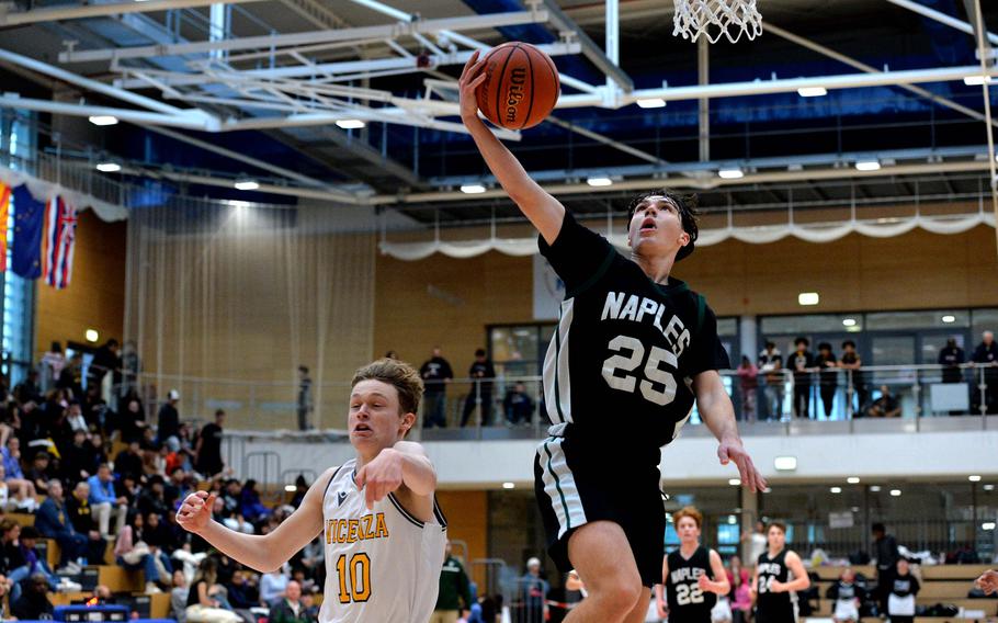 Naples’ Jettyn Jones finishes a fast break ahead of Vicenza’s Dylan Horrigan in the boys Division II final at the DODEA-Europe basketball championships in Wiesbaden, Germany, Feb. 17, 2024. Vicenza defeated Naples76-37 to take the title.