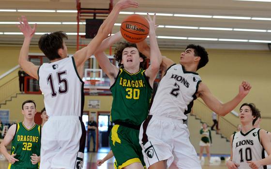 AFNORTHs Nathan Goldsmith, left, and Ronnie Macauley stop Alconburys Bohdan Andres drive to the basket  in a D-III game on opening day of the DODEA-Europe basketball finals in Baumholder, Germany, Feb. 15, 2023. The Lions beat the Dragons 66-47. 